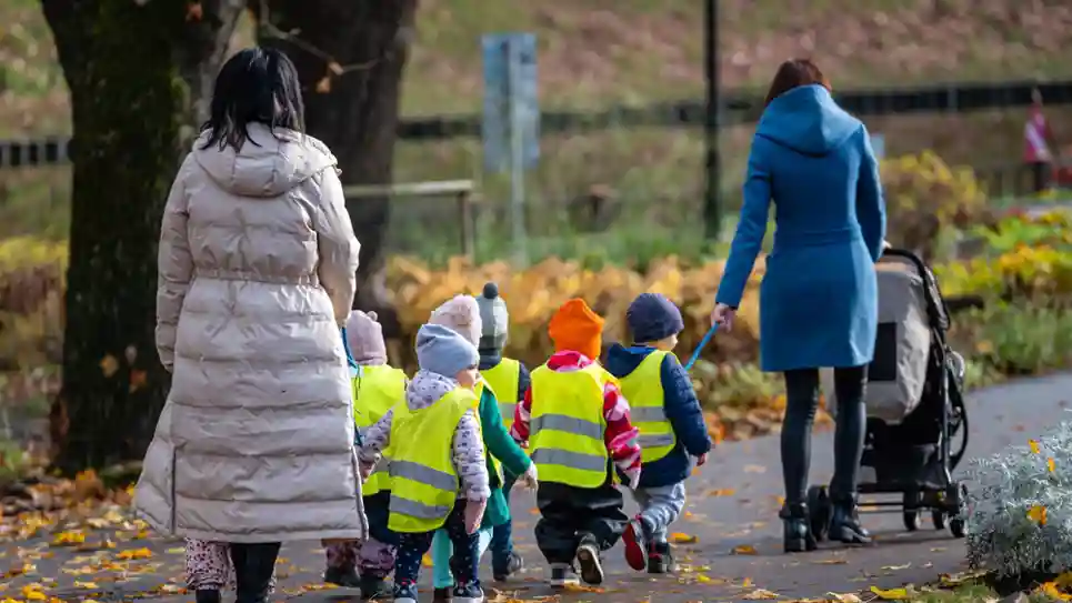 gro-up kinderen groepje loopt onder begeleiding twee volwassenen