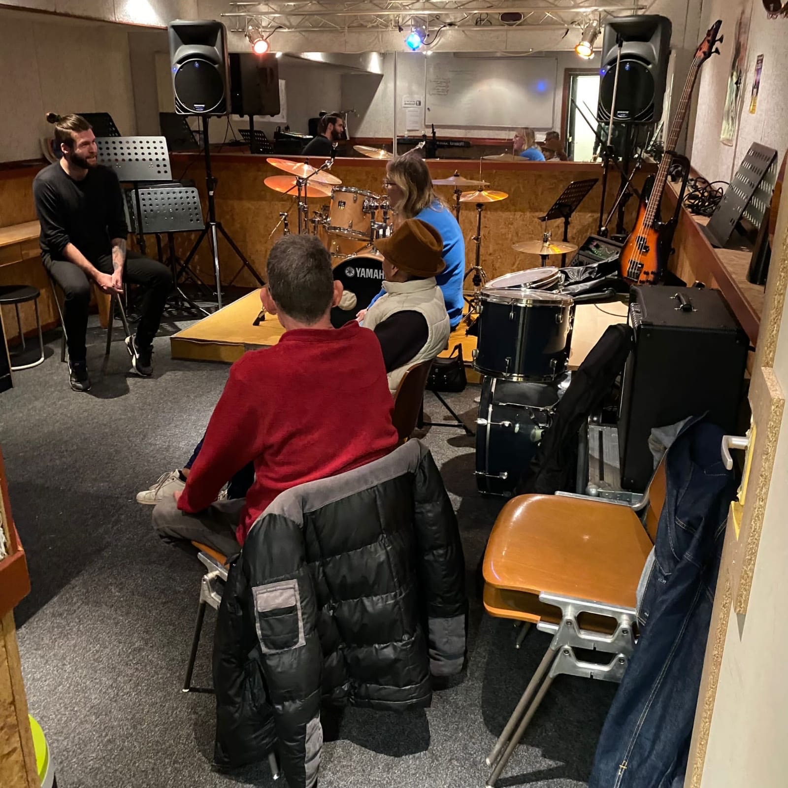 gro-up volwassenen praten tussen muziekinstrumenten