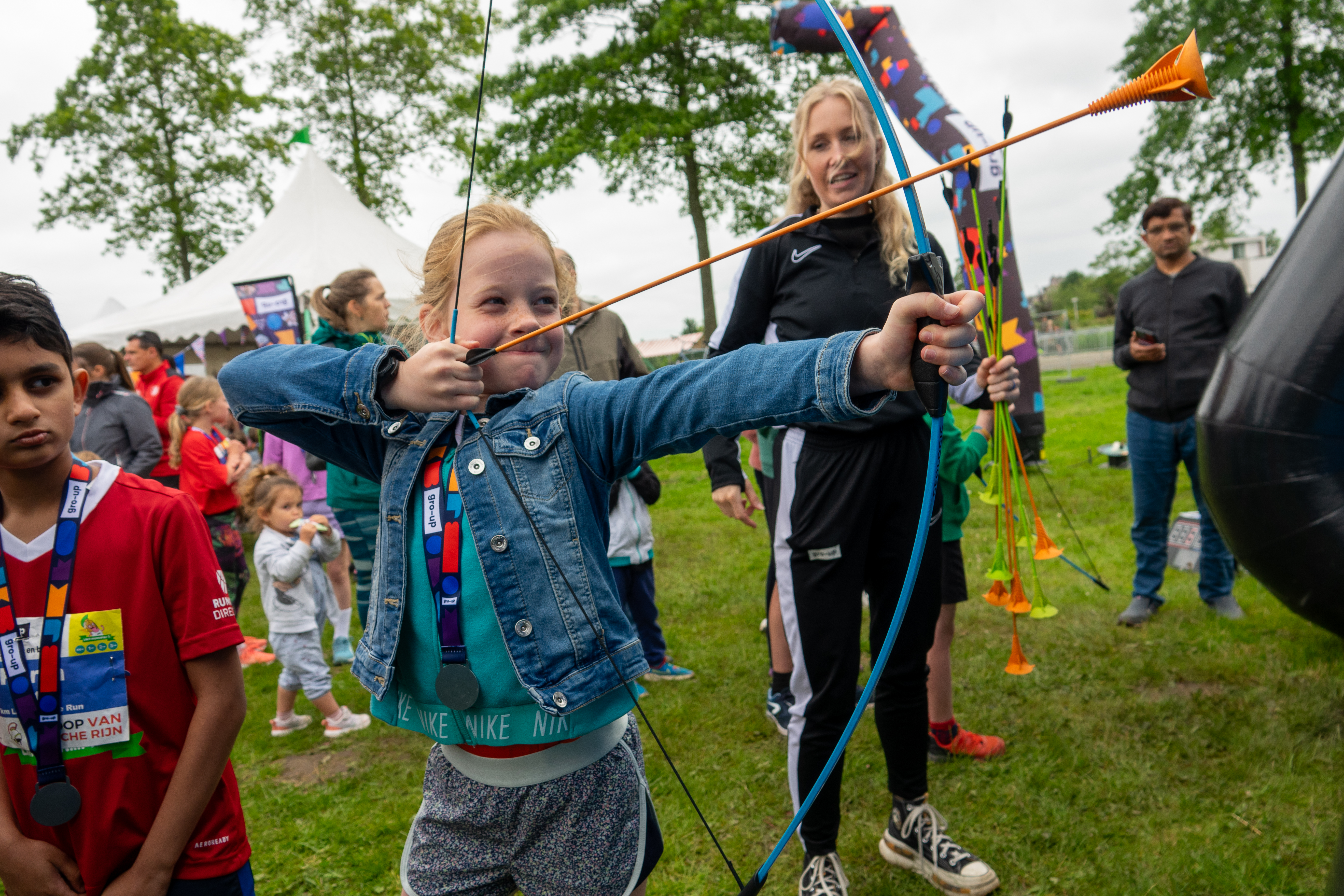 Een meisje boogschiet in de kids corner tijdens de gro-up Lint-Wurmpie Run
