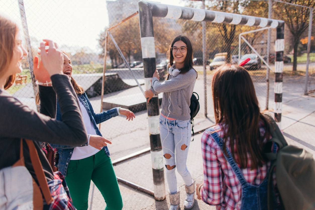 Drie jongere meisjes hangen op een voetbalplein in Uithoorn
