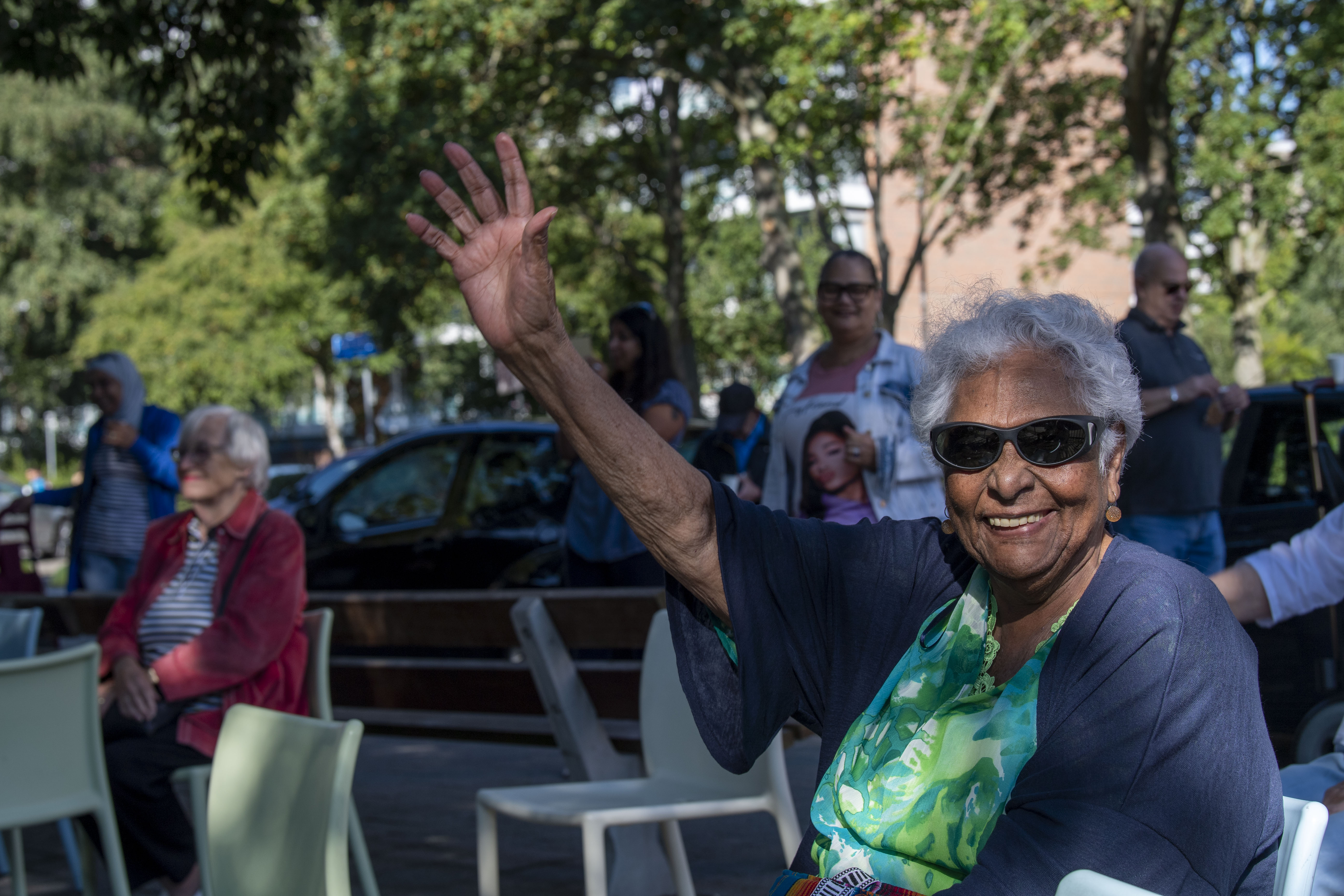 Oudere dame viert feest, buiten bij Huis van de Wijk Zevenkamp van gro-up buurtwerk