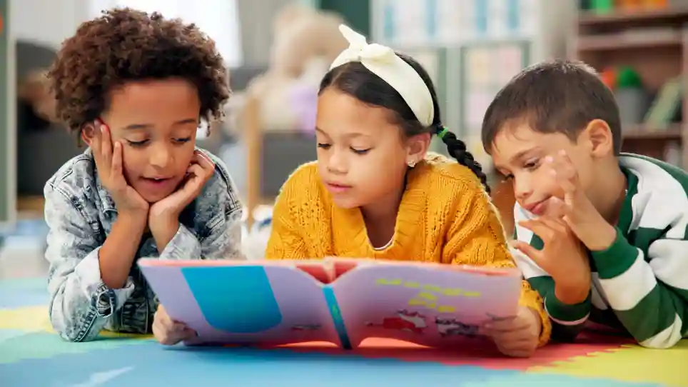 Buitenschoolse opvang Onyx van gro-up Drie kinderen lezen samen bij buitenschoolse opvang Onyx van gro-up