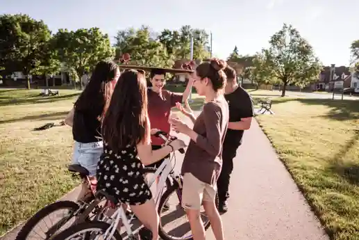 Jongerenhub De Esch Jongeren praten met elkaar in een park in De Esch, sommige op de fiets, een met ene skateboard