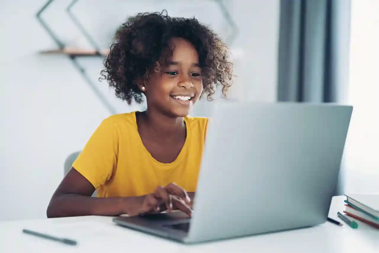 Mediawijsheid gro-up buurtwerk Tienermeisje zit achter een laptop en drukt op een knop