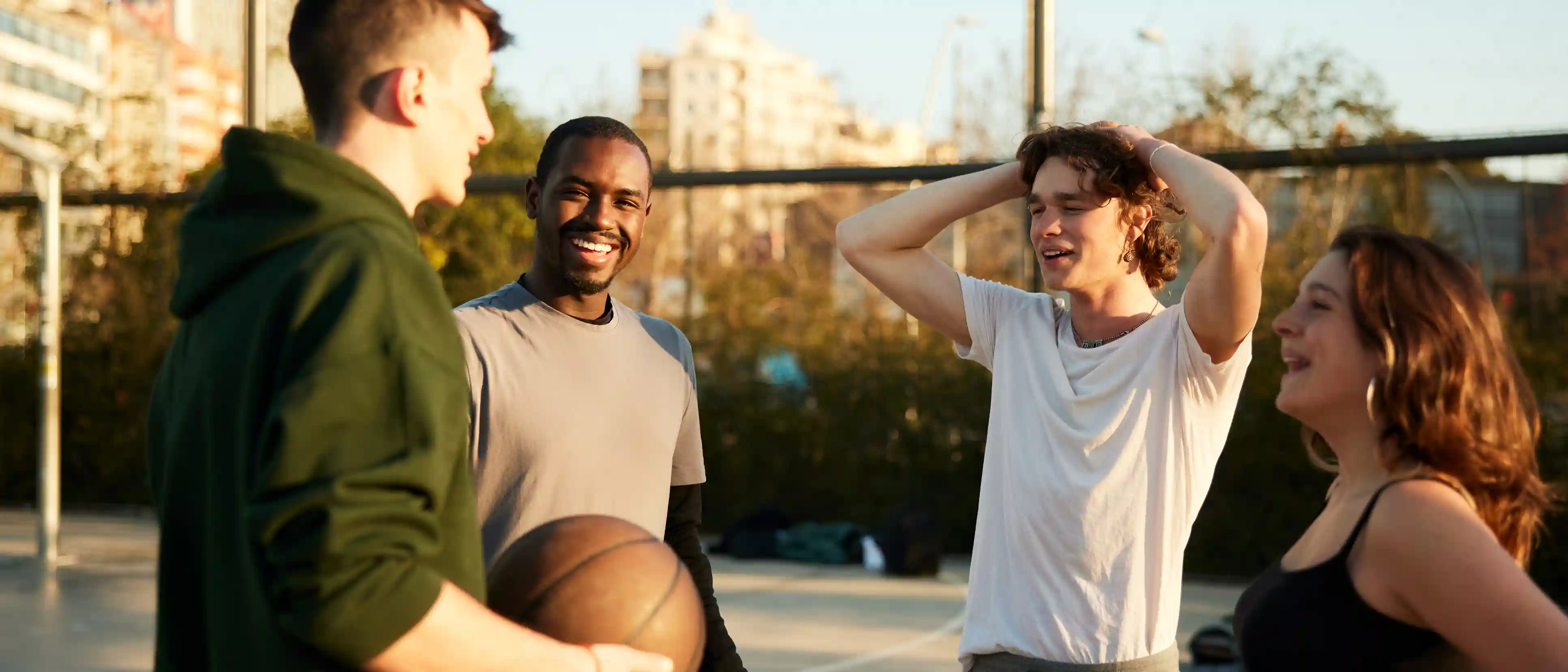 Onze buurten Krimpenerwaard Vier jongeren praten met elkaar op een basketbalveld in Krimpenerwaard