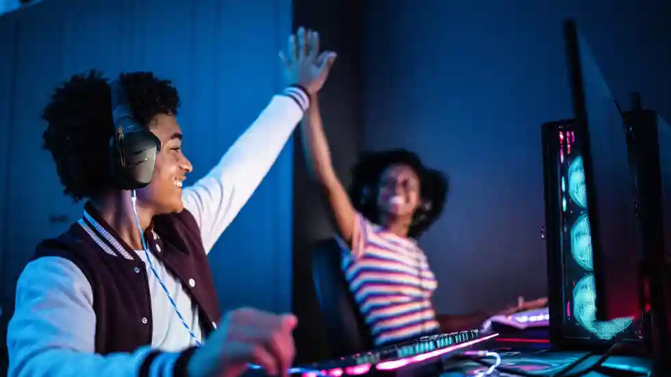 Mediawijsheid in de buurt Een gamende jongen en meisje geven elkaar een high five