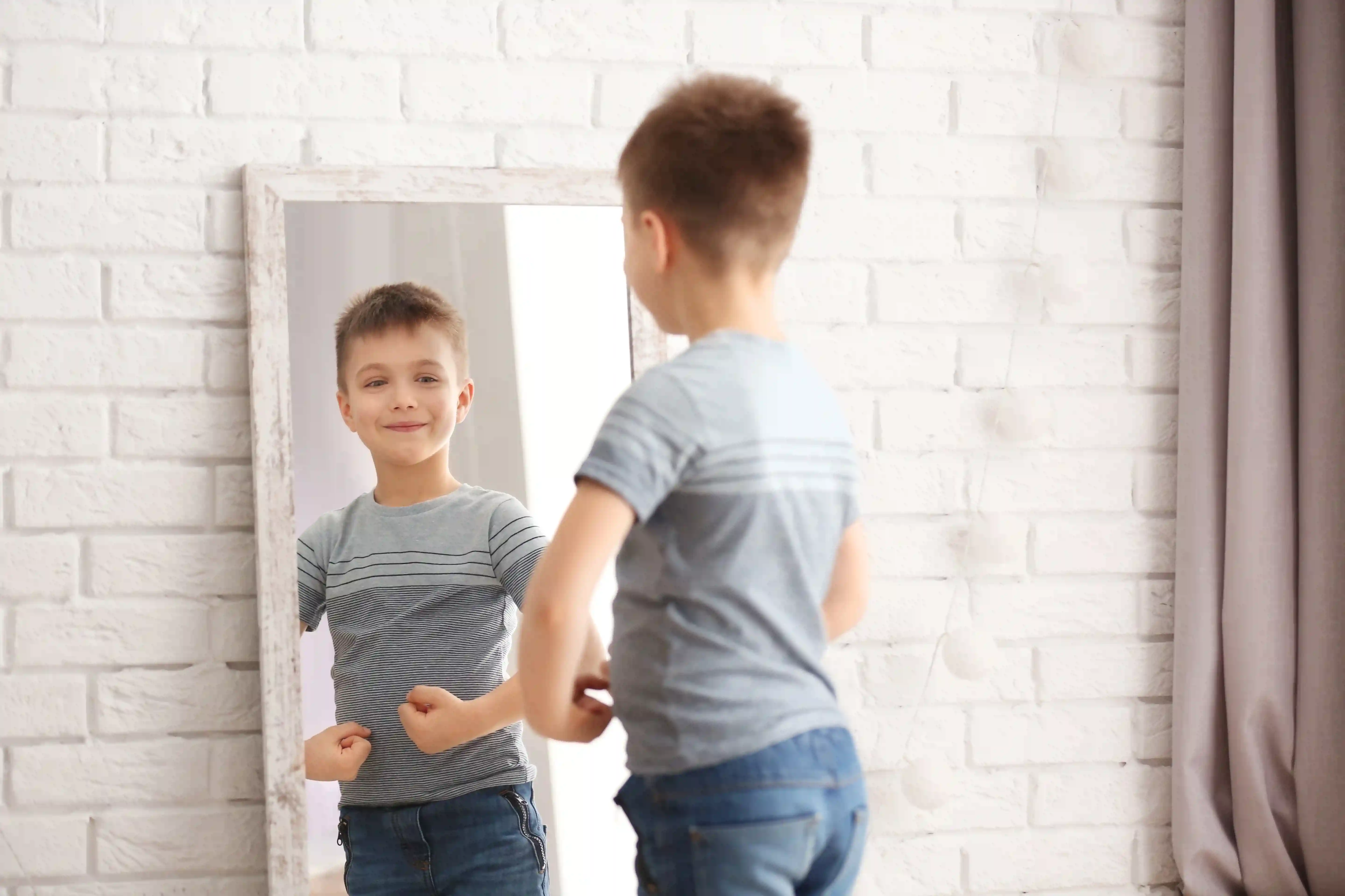 gro-up jongetje kijkt in de spiegel hoe sterk hij is