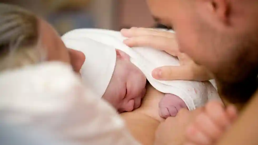 gro-up baby met vrouw en man gro-up baby ligt op moeders borst en wordt geaaid door vader