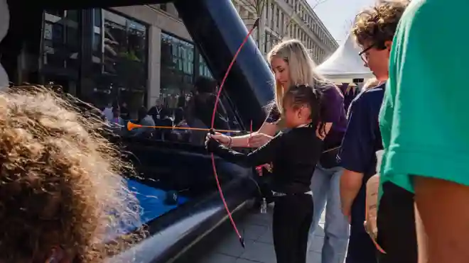 gro-up Kids Run Marathon Rotterdam Kids Corner Boogschieten Een meisje krijgt uitleg over boogschieten in de kids corner van gro-up tijdens de NN Kids Run van de Marathon Rotterdam