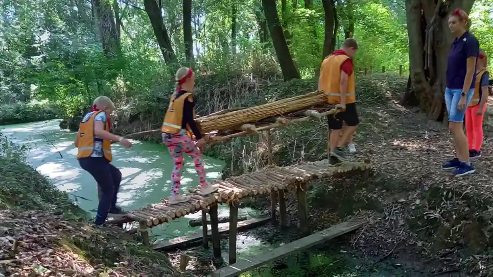 gro-up kinderen dragen stokken tijdens de campingweek