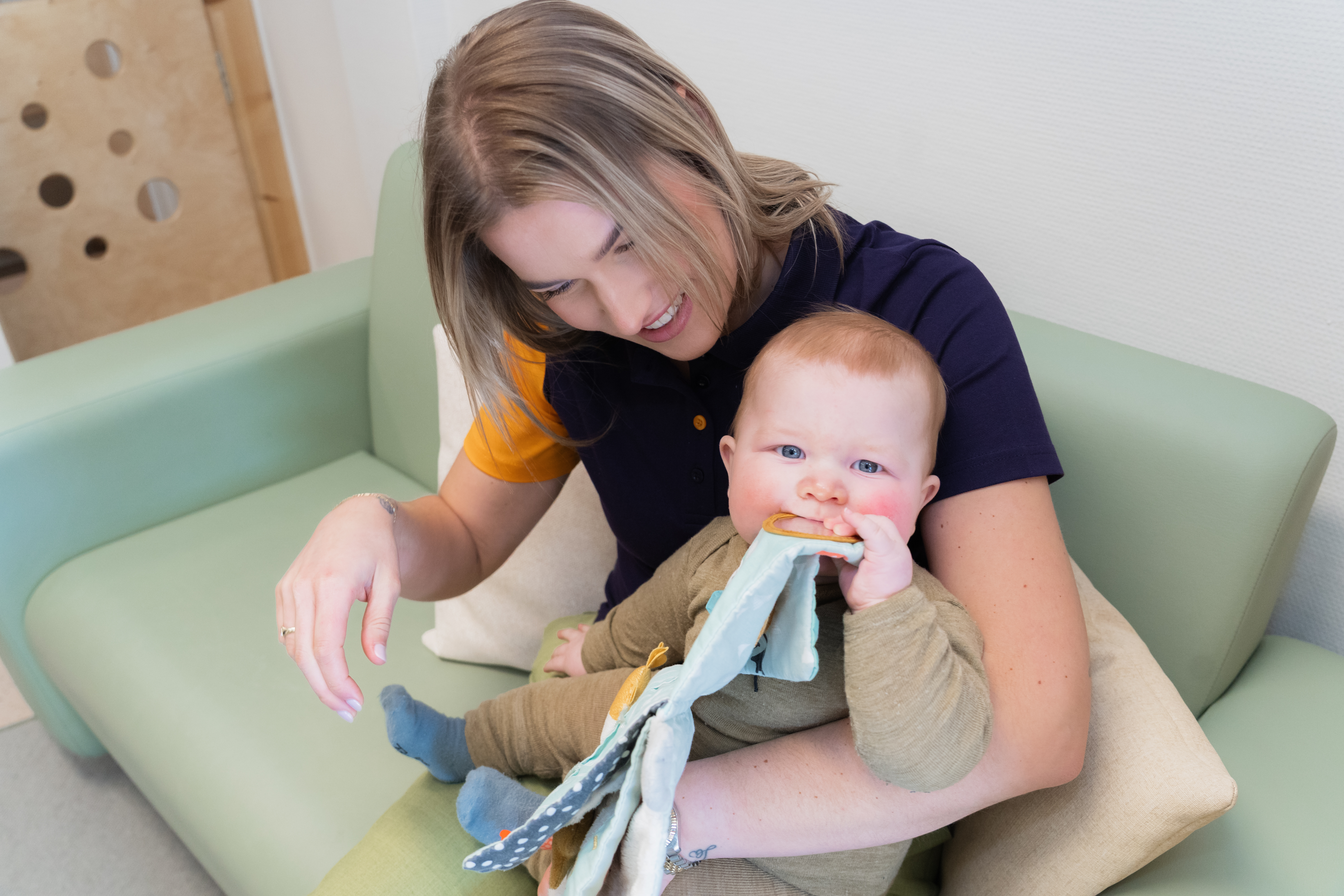 Baby met knisperboekje op het kinderdagverblijf van gro-up
