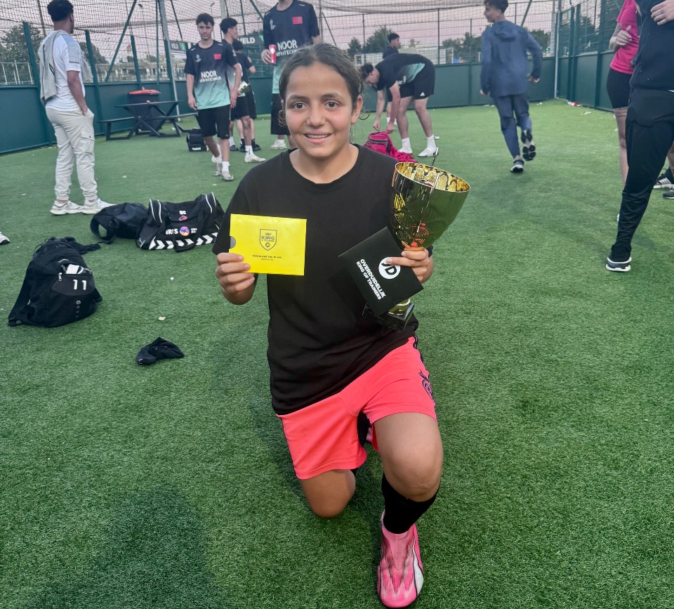 De Winnares van de Buurtwerk Cup 2025 poseert met haar beker