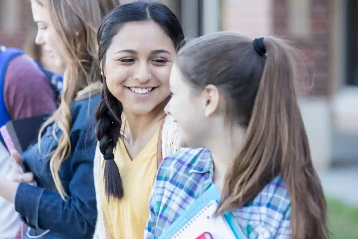 Girls Talk gro-up buurtwerk Twee meisjes kletsen buiten met elkaar