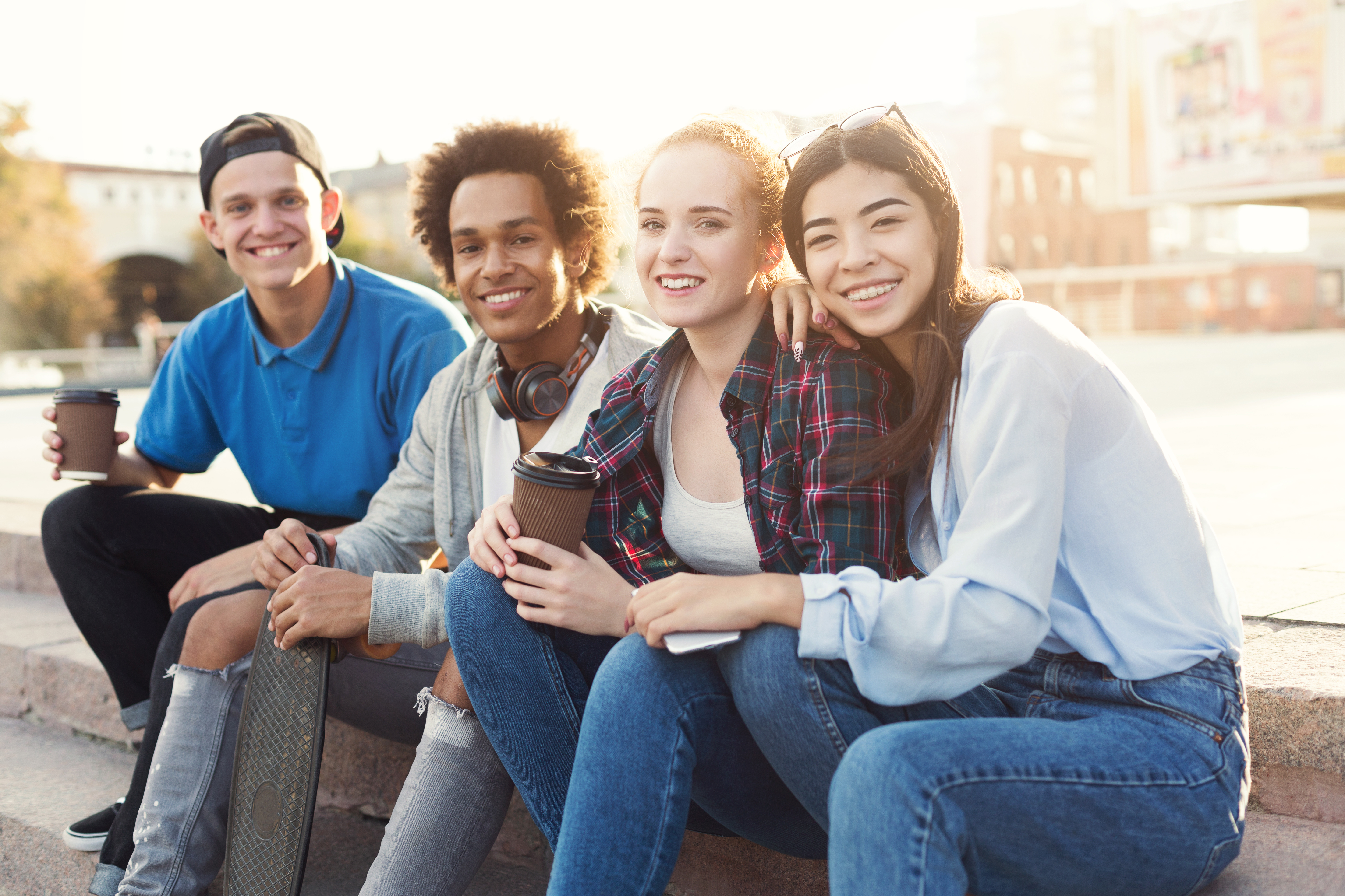 Groep (jong)volwassenen met een koffie op een buitentrap