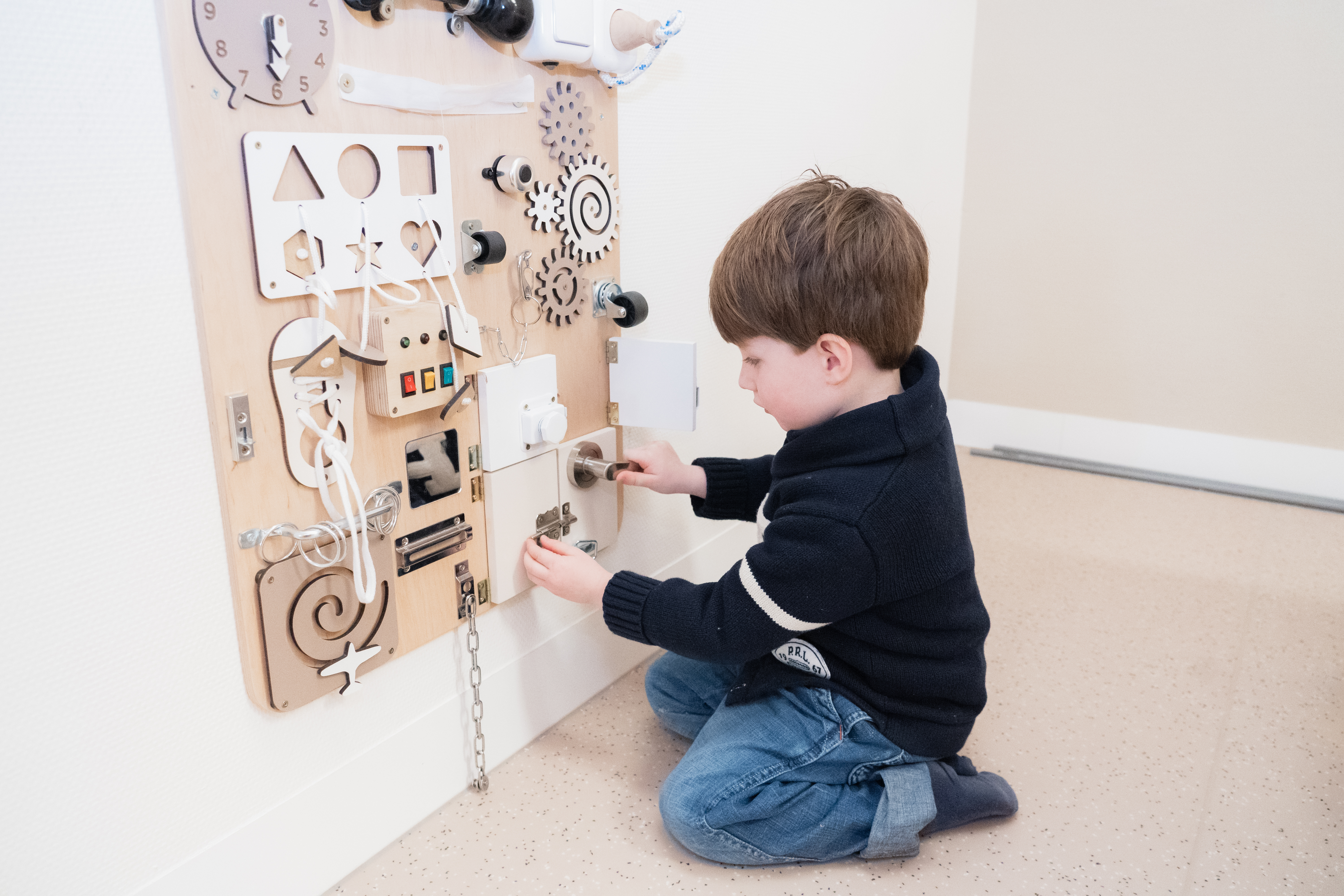 Jongen speelt met een speciale speelgoed wand van gro-up bij buitenschoolse opvang Het Spectrum