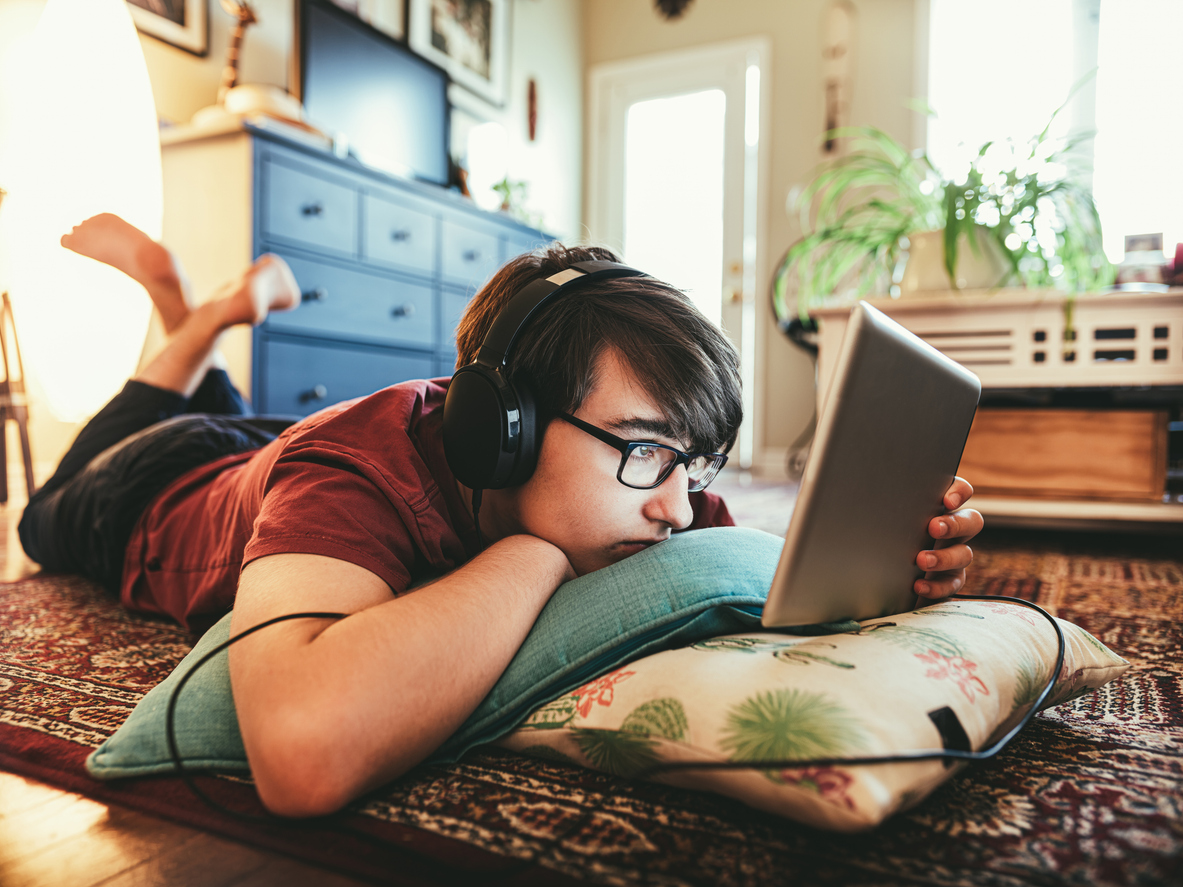 Jongen met koptelefoon kijkt naar tablet