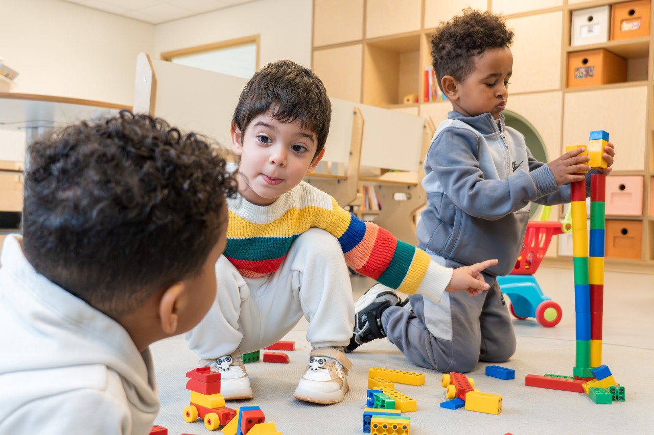 Drie jongens spelen samen met Duplo tijdens een Samenspeelgroep van gro-up in Rotterdam