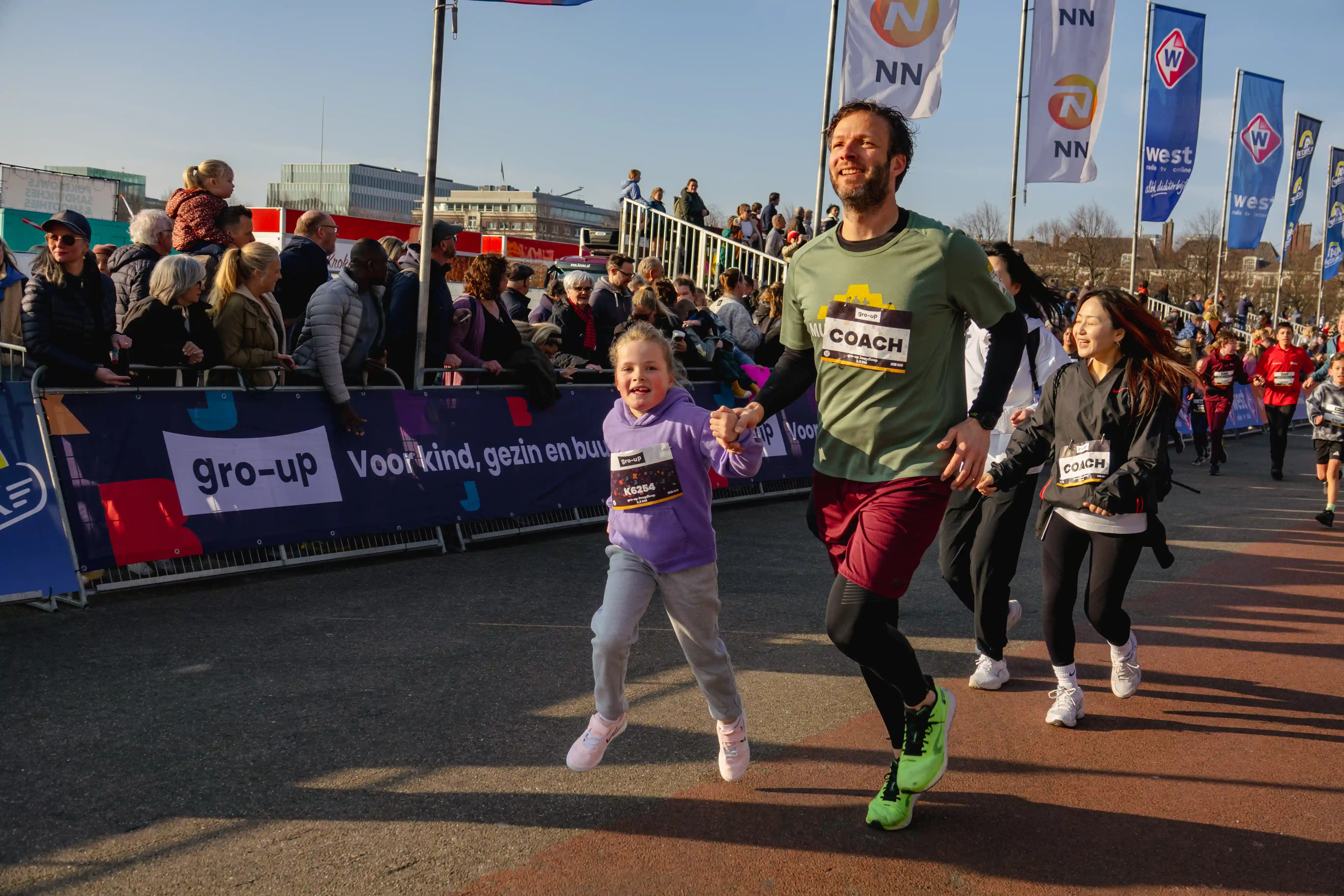 Een meisje en haar vader lopen de gro-up Jeugdlopen van de CPC Loop Den Haag