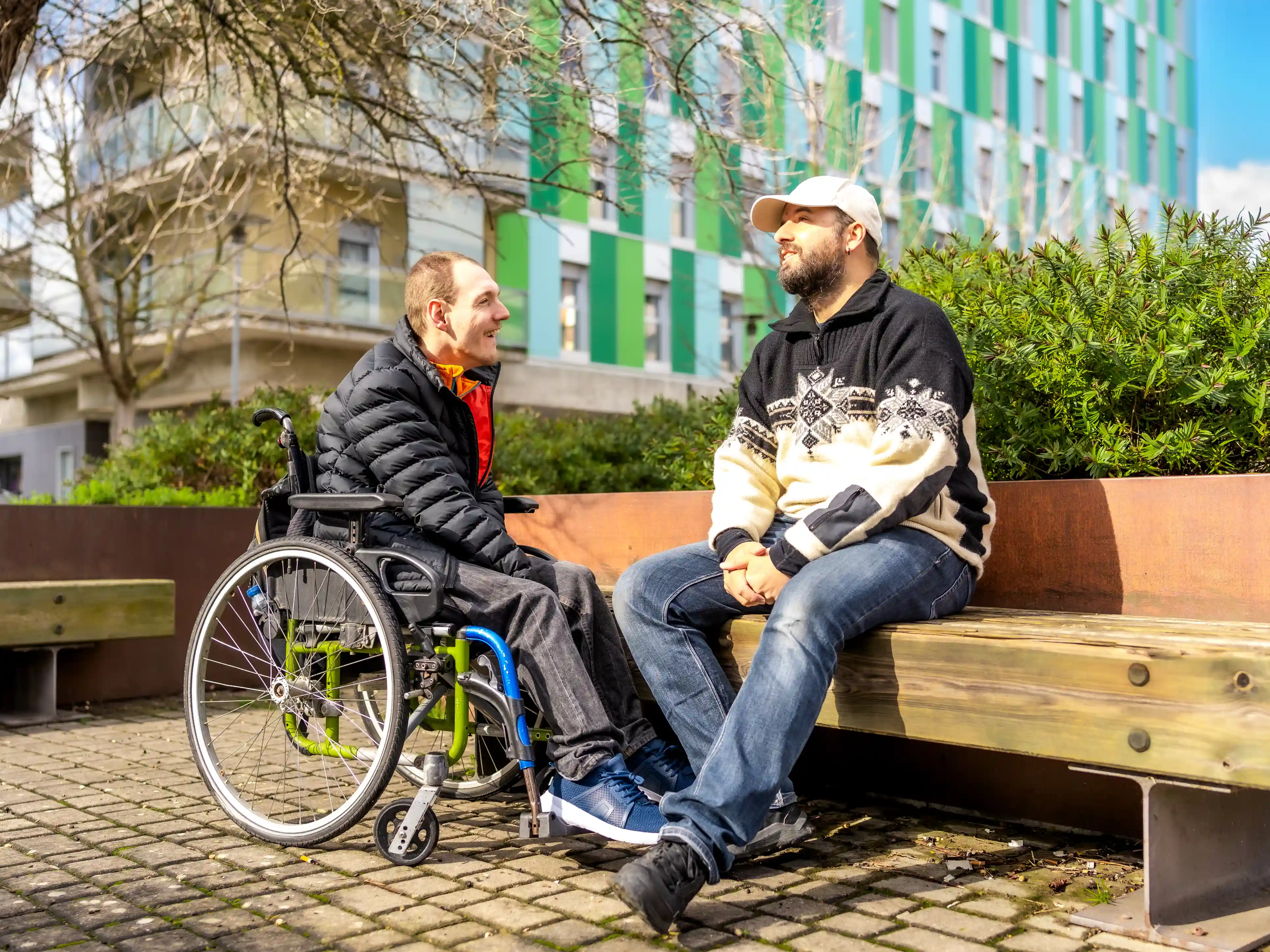 Samen in de wijk dankzij volwassenenwerk van gro-up Twee mannen, een in een rolstoel en een op een bankje, zitten te praten over hun wijk