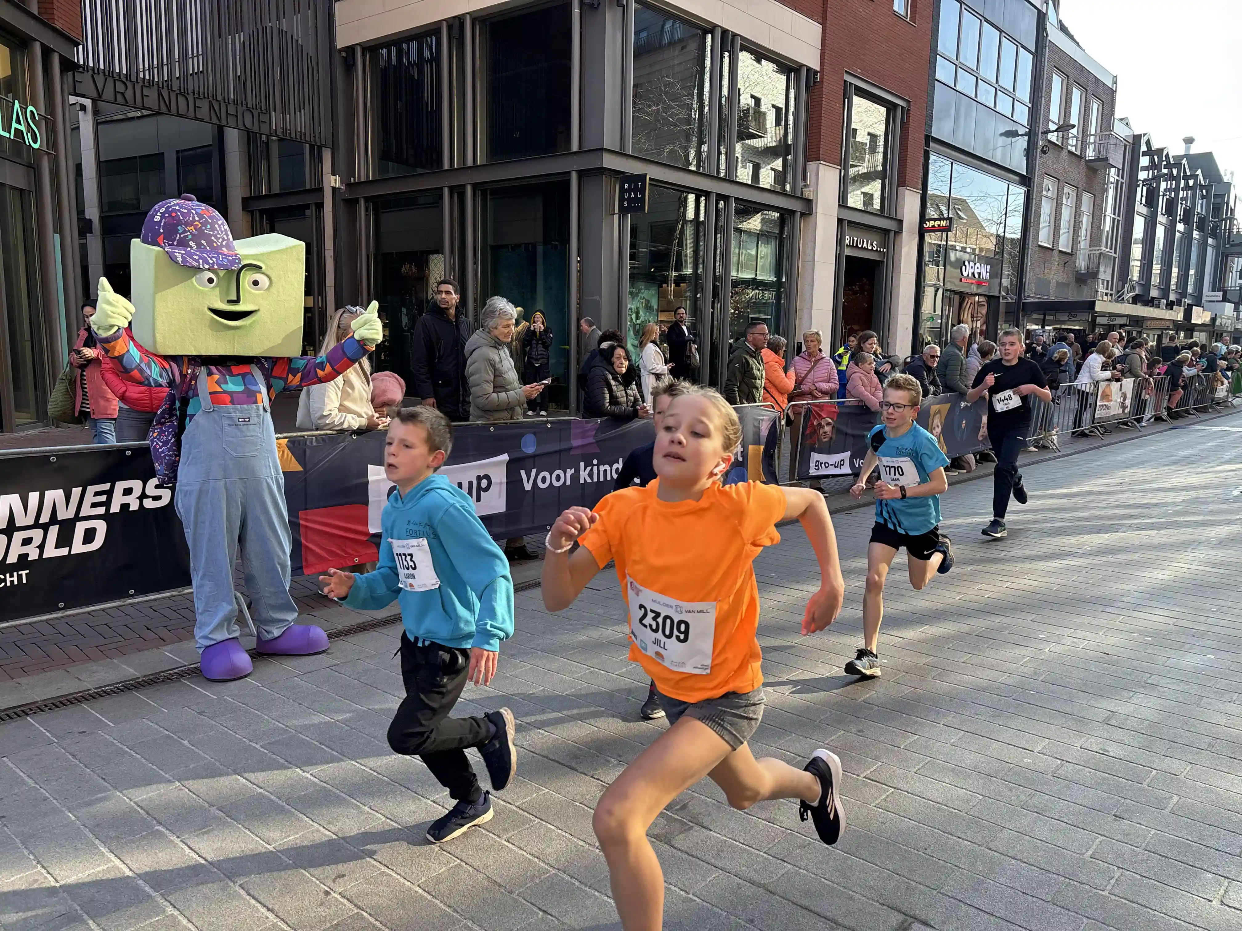 gro-up DrechtStadLoop Kinderen rennen aangemoedigd door mascotte grup door het centrum van Dordrecht tijdens de DrechtStadLoop