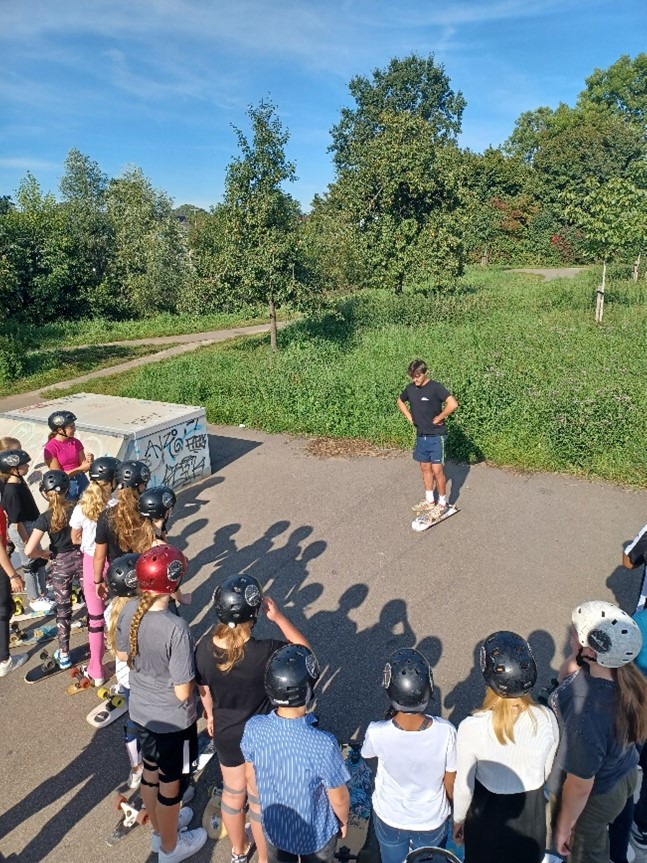 Deelnemers luisteren aandachtig bij een skateworkshop georganiseerd door gro-up buurtwerk Vijfheerenlanden