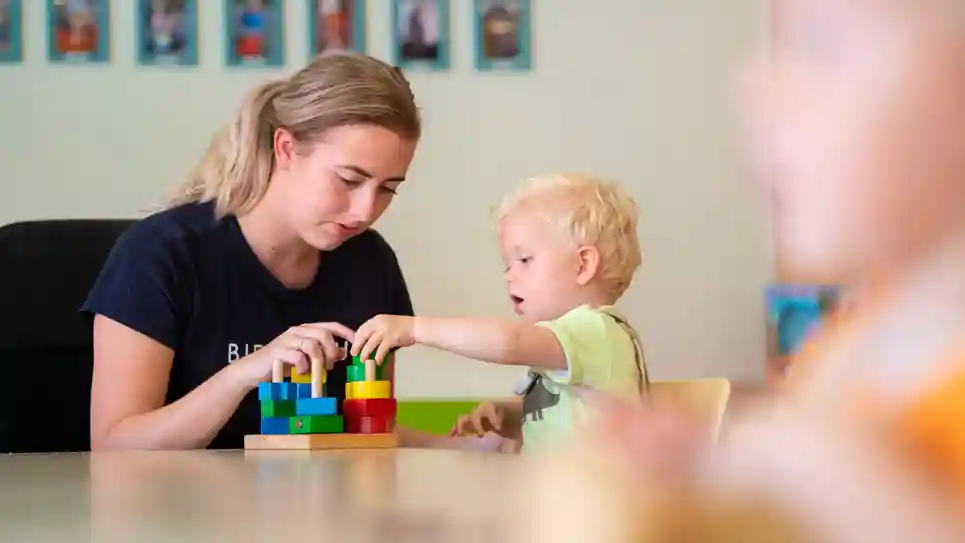 gro-up kind peuter speelt met blokken met pedagogisch medewerker