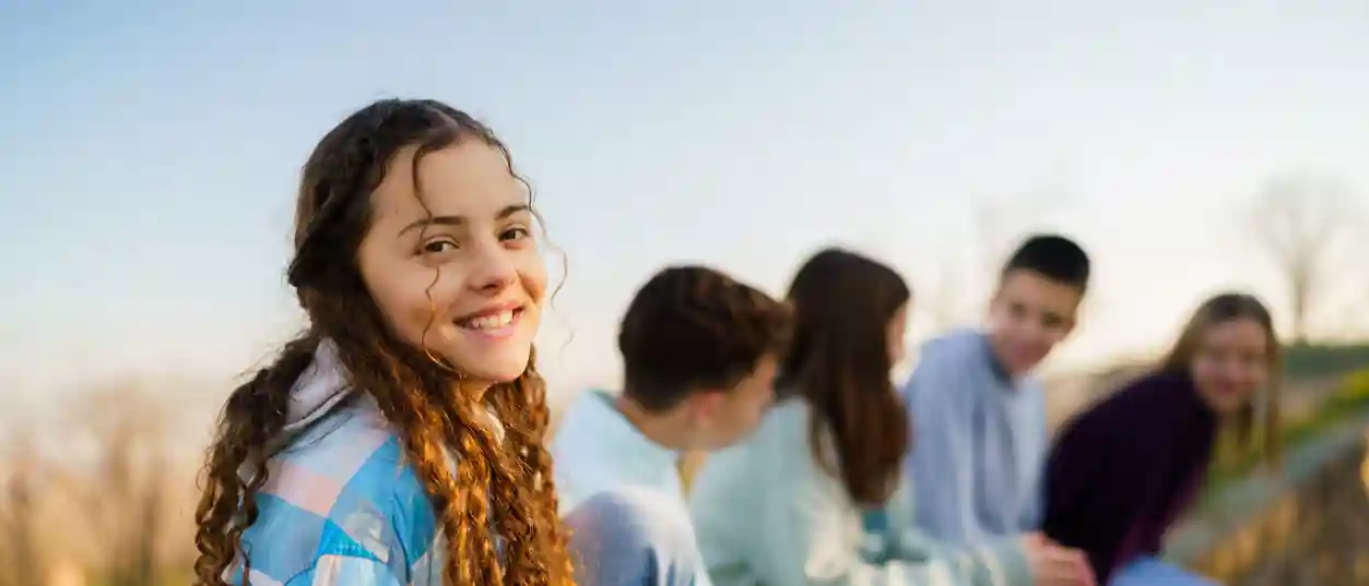 gro-up jeugd zit op een rij naast elkaar en een meisje lacht gro-up jeugd zit op een rij naast elkaar en een meisje lacht