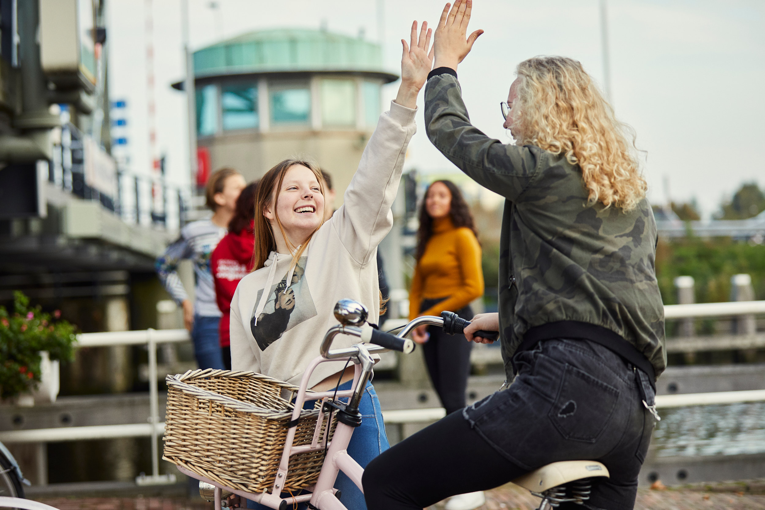 High five tussen twee meisjes die elkaar ontmoeten bij De Steigers in Schiedam Groenoord van gro-up buurtwerk