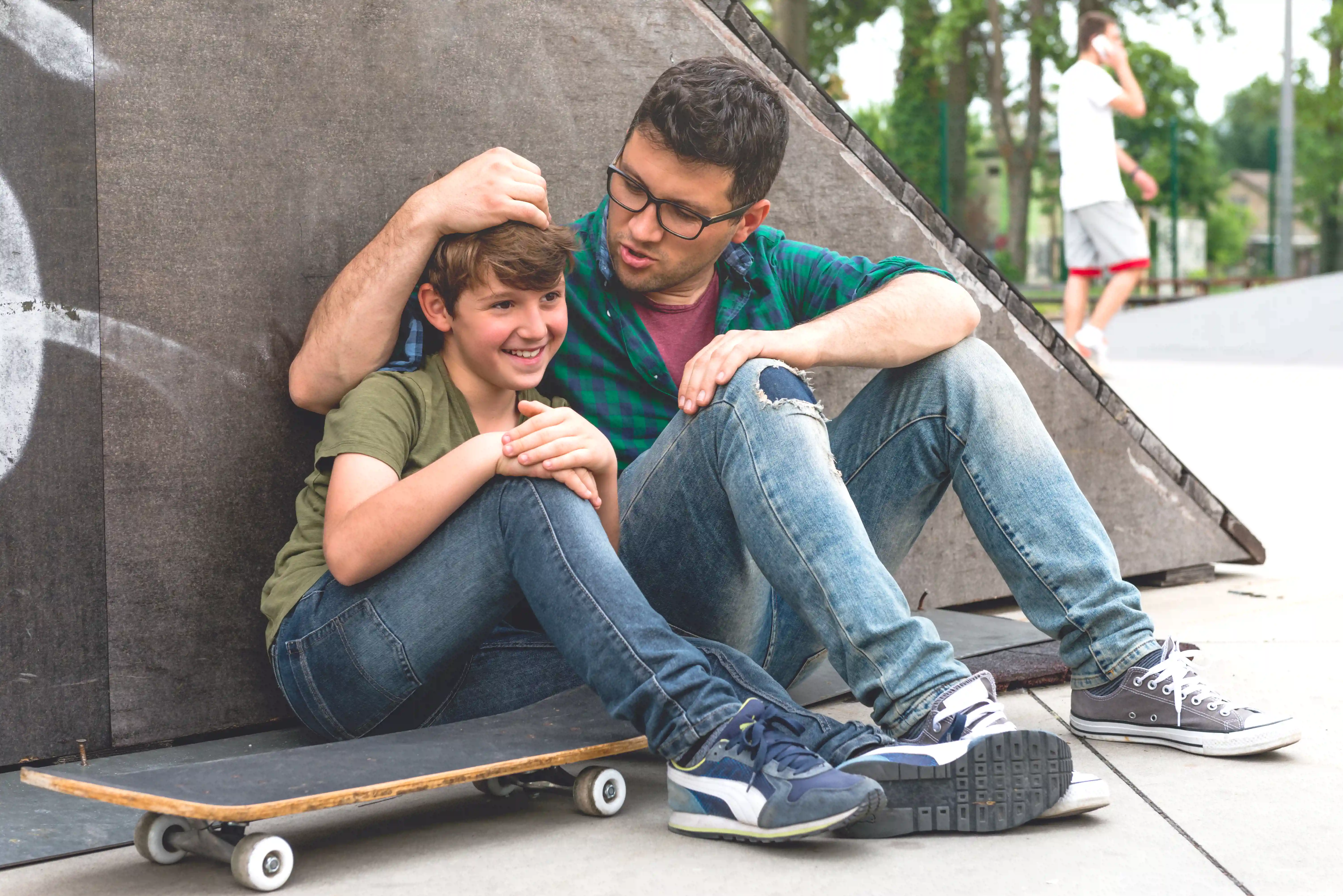 gro-up jongen krijgt aai over de bol in skatepark