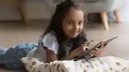 gro-up kind meisje met tablet op de grond Hoe je om kunt gaan met schermtijd tijdens de vakantie