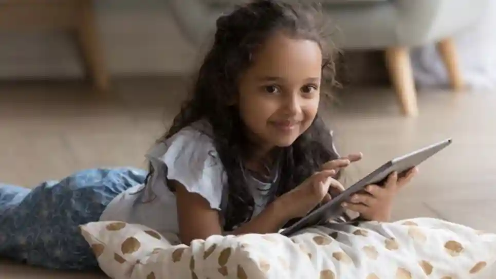 gro-up kind meisje met tablet op de grond Hoe je om kunt gaan met schermtijd tijdens de vakantie