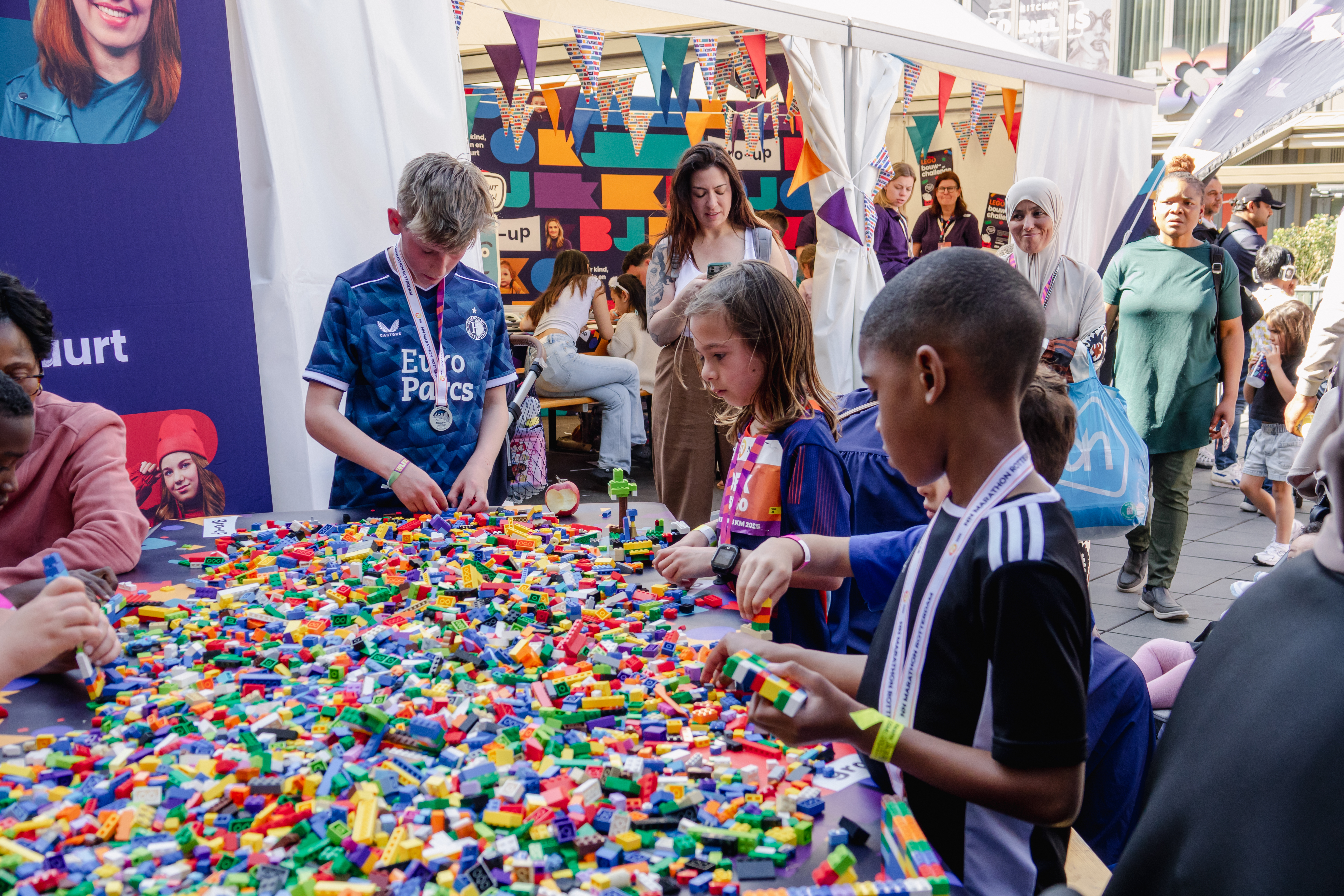 Kinderen spelen met Lego in de kids corner tijdens de NN Kids Run van de Marathon Rotterdam