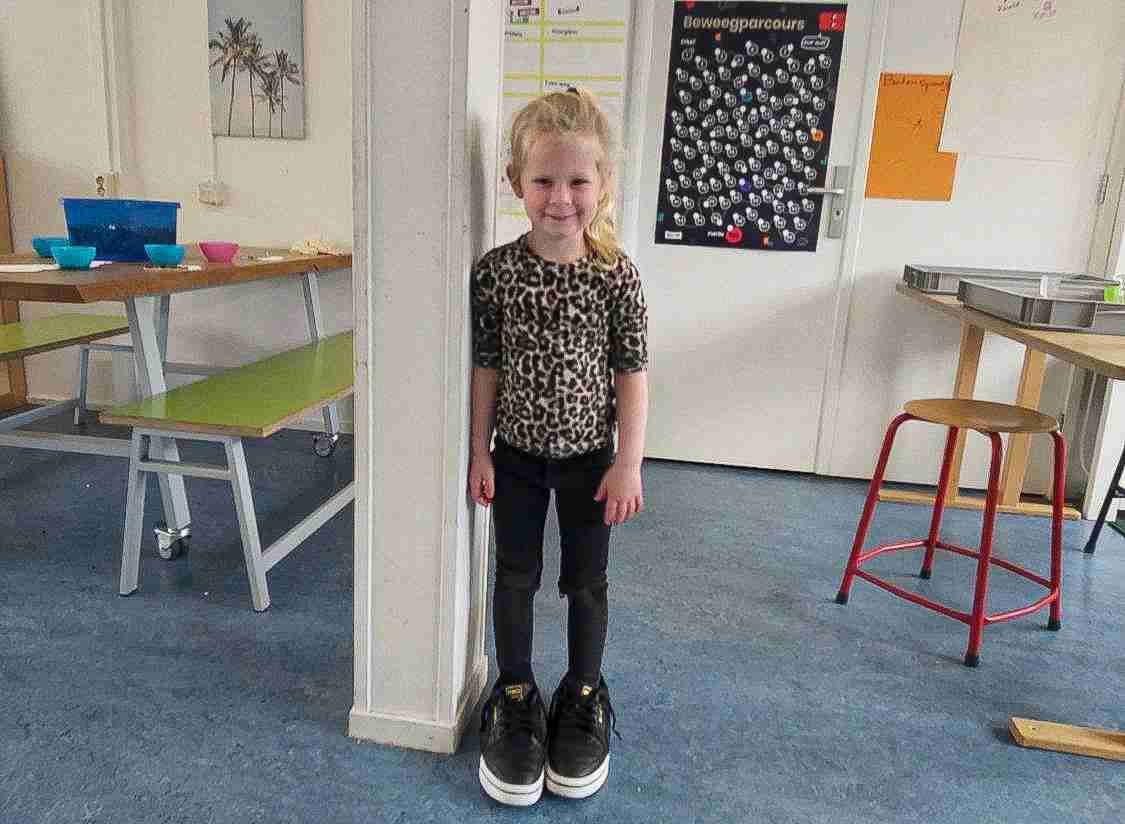 Meisje schoolkind draagt grote schoenen