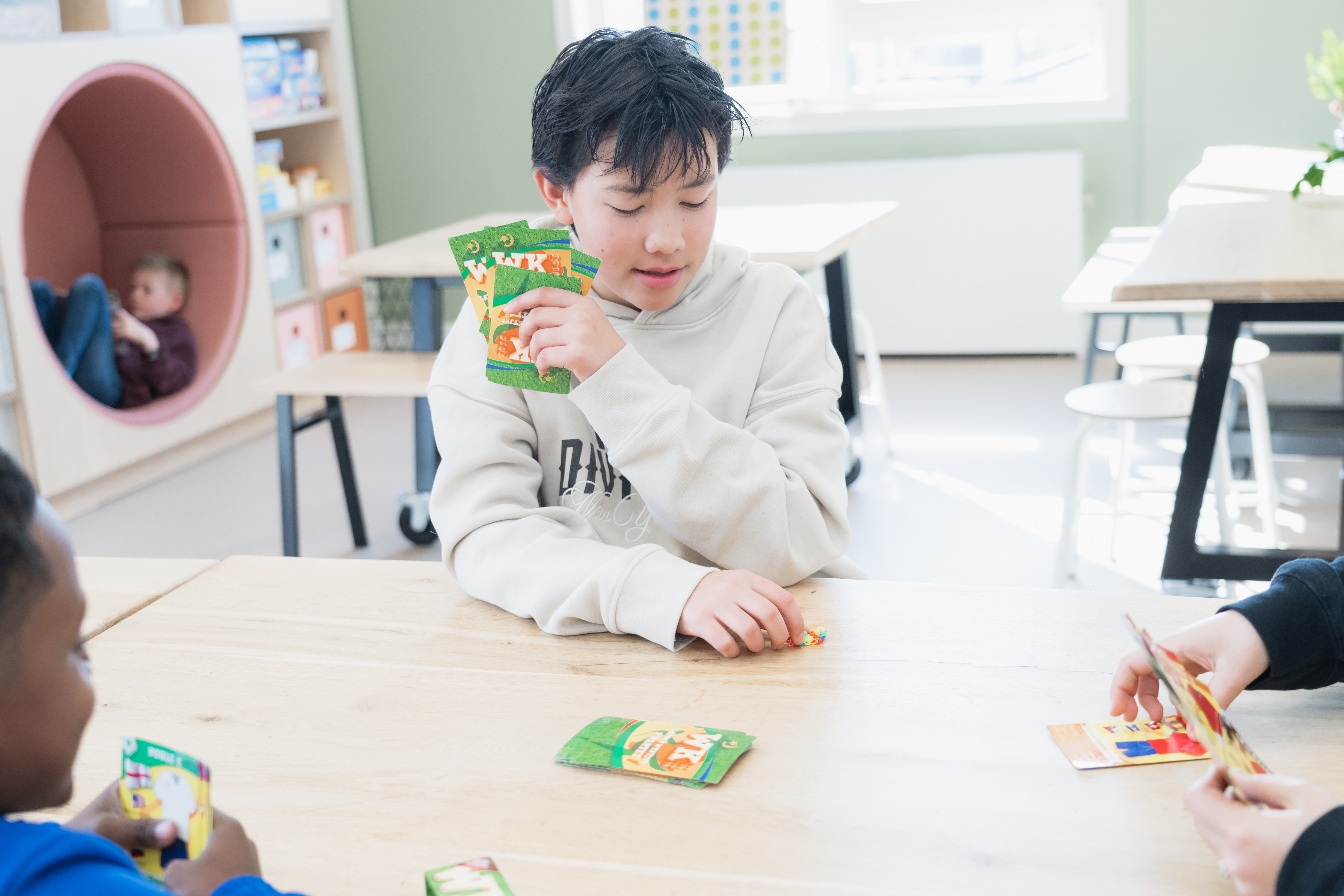 Jongens spelen een kaartspelletje bij buitenschoolse opvang De Driehoek van gro-up
