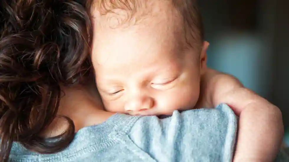 gro-up baby tegen vrouw aan gro-up baby ligt op schouder van een vrouw