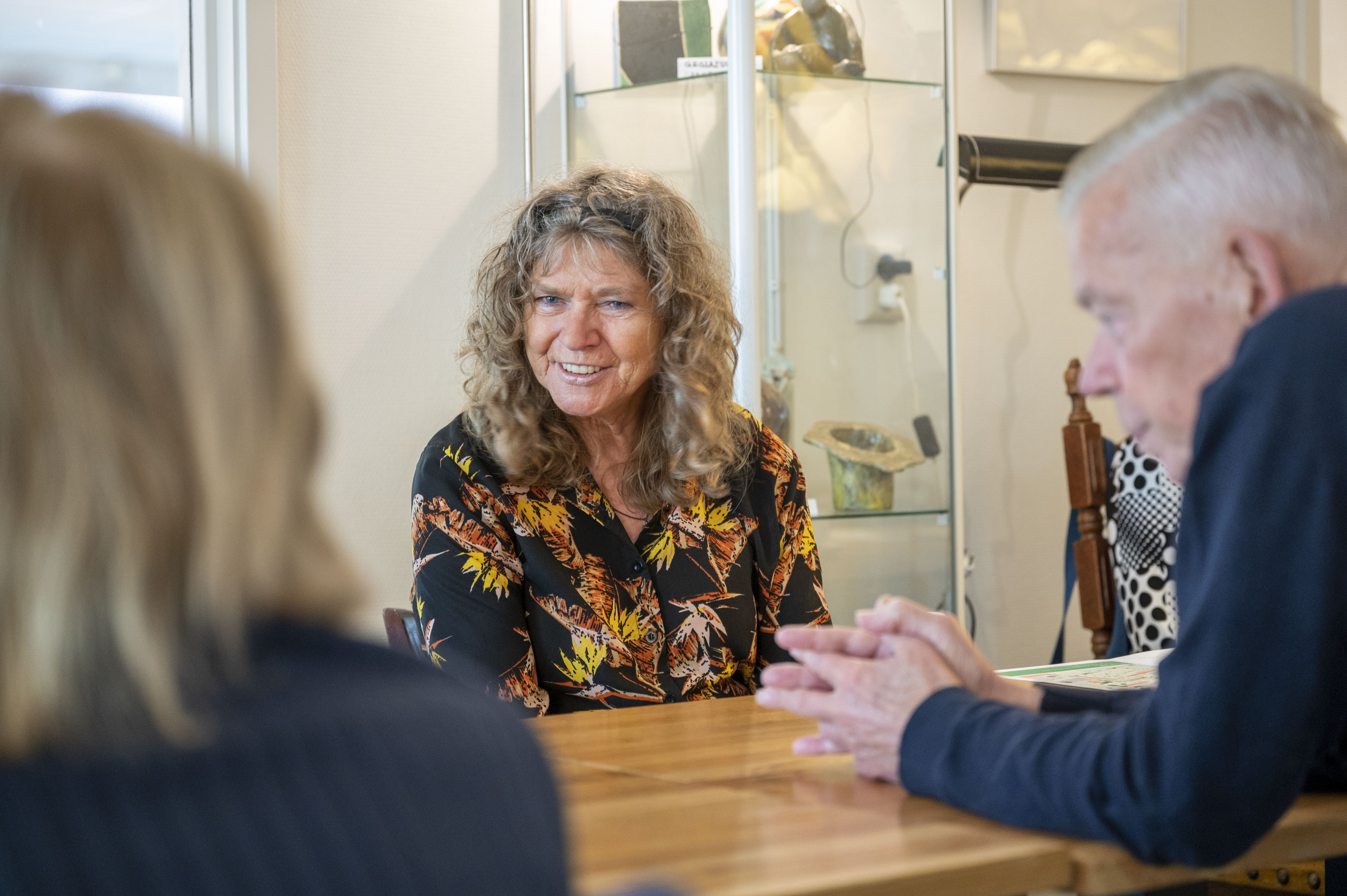 Een oudere dame luistert naar mooie verhalen in Huis van de Wijk Rendierhof van gro-up buurtwerk