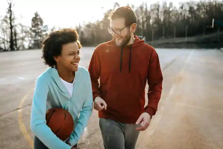 Jongere met basketbal en jongerenwerker