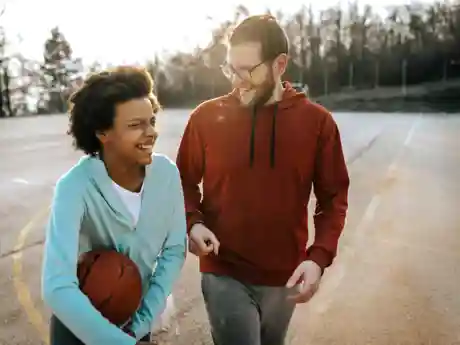 Jongerenwerk Jongere met basketbal en jongerenwerker