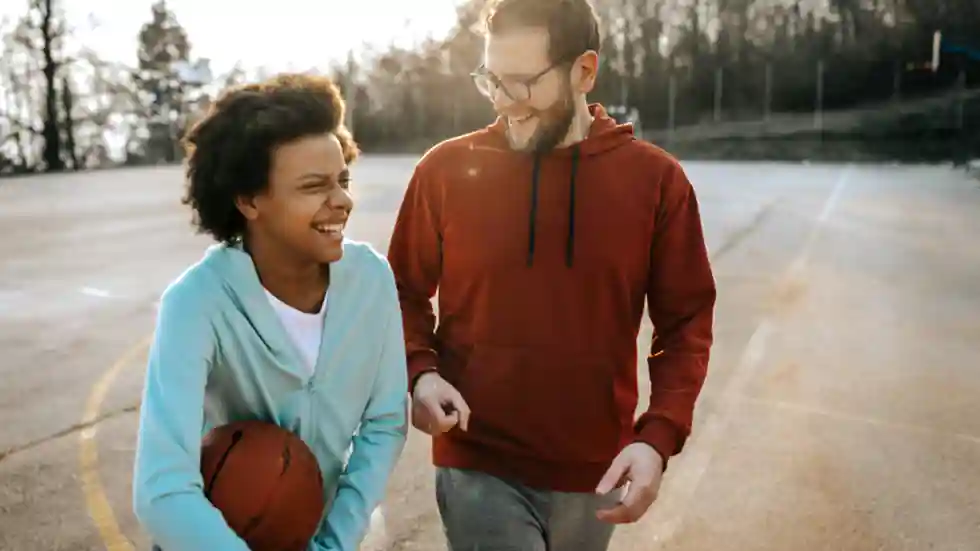 Jongerenwerk Jongere met basketbal en jongerenwerker