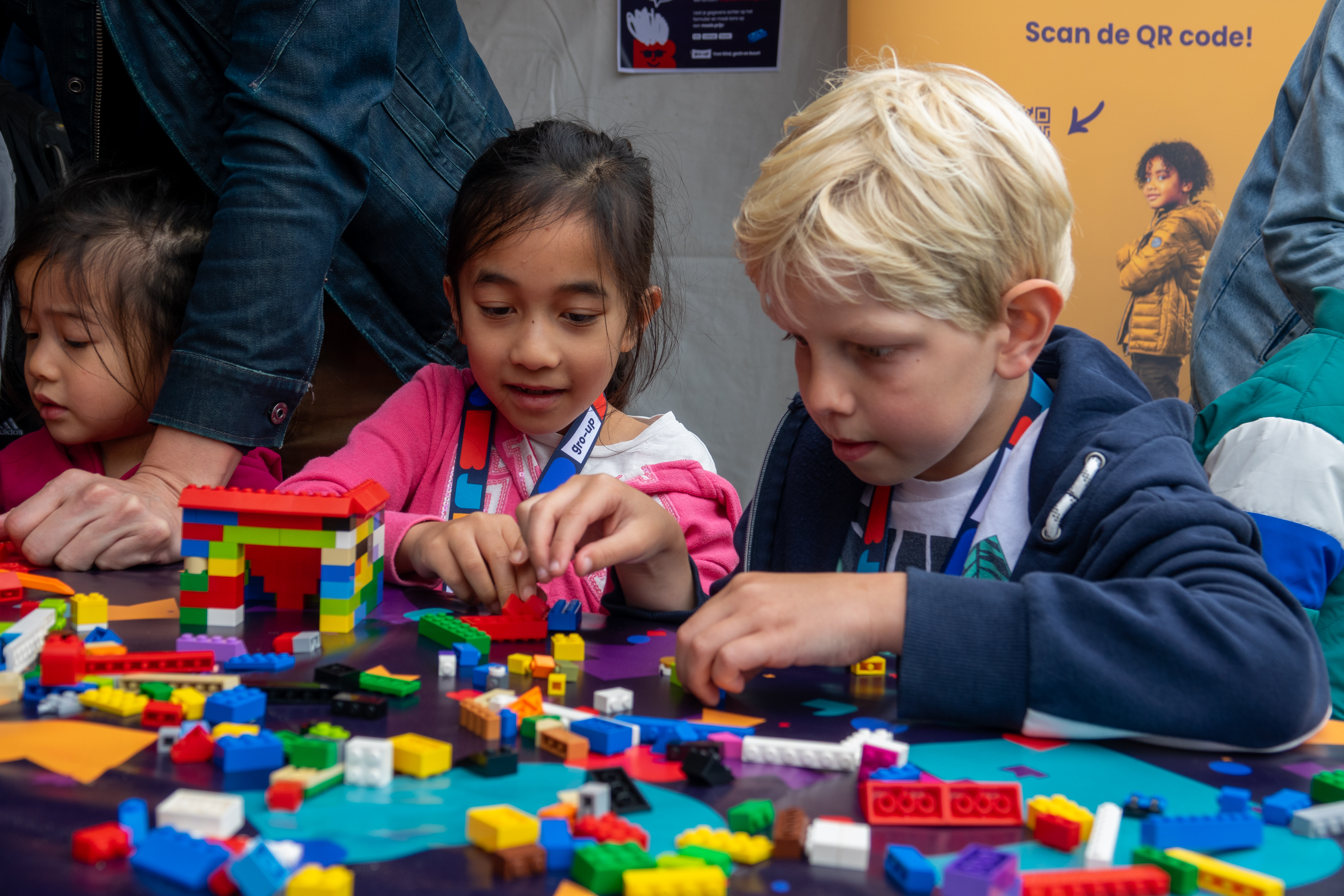 Een jongen en twee meisjes spelen met Lego in de kids corner tijdens de gro-up Lint-Wurmpie Run