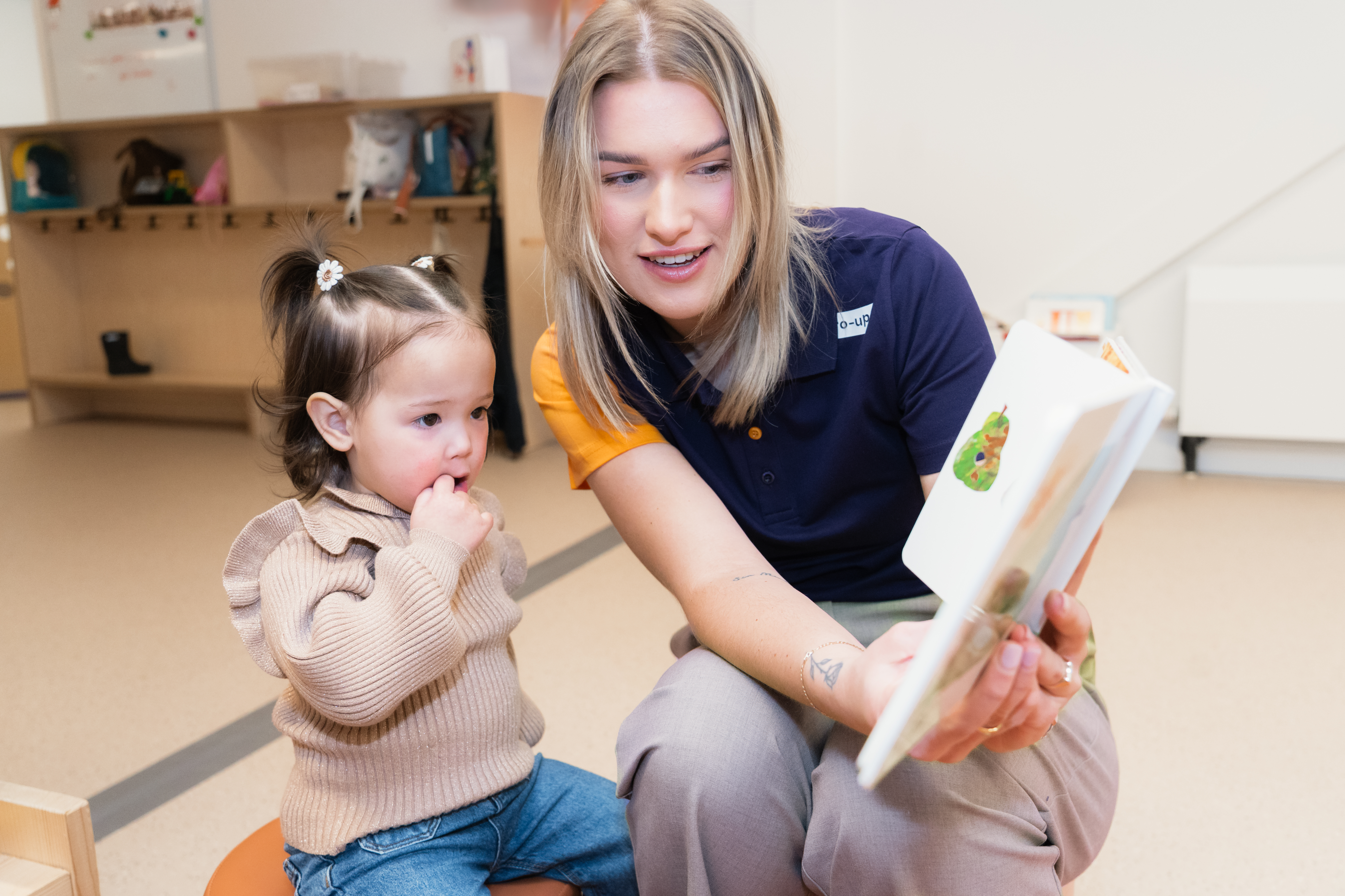 gro-up kinderdagverblijf pedagogisch medewerker leest een boekje voor