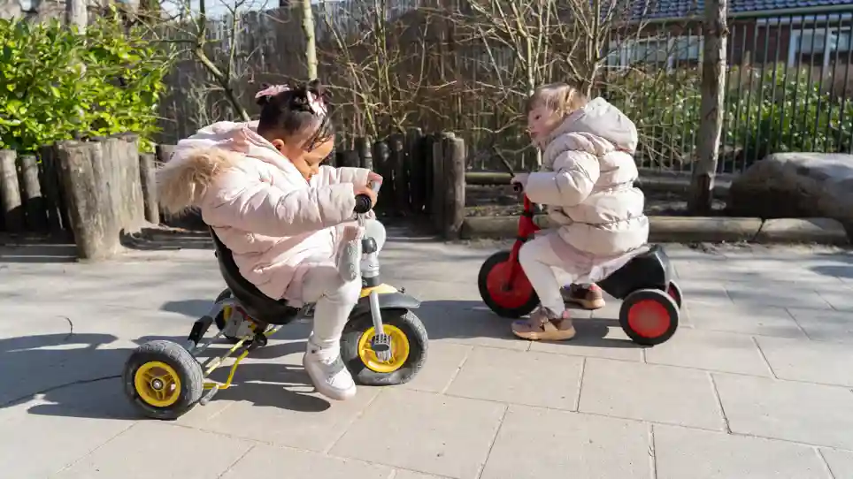 Het Spectrum, een peuteropvang van gro-up Kinderen spelen buiten op driewielers bij peuteropvang Het Spectrum van gro-up